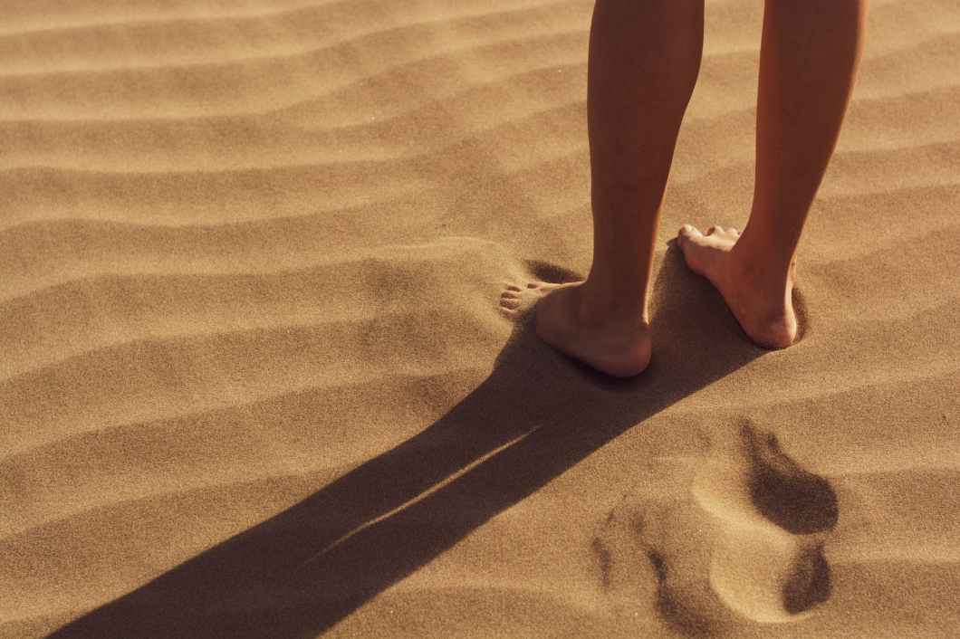 person stand on sand
